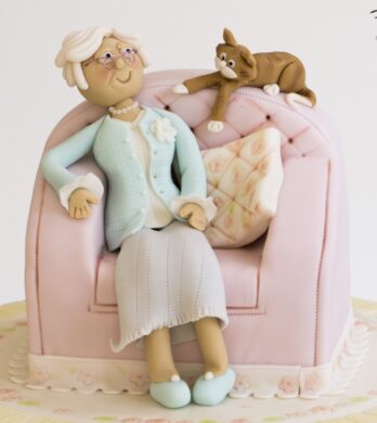 old lady sitting in here chair with a cake cake