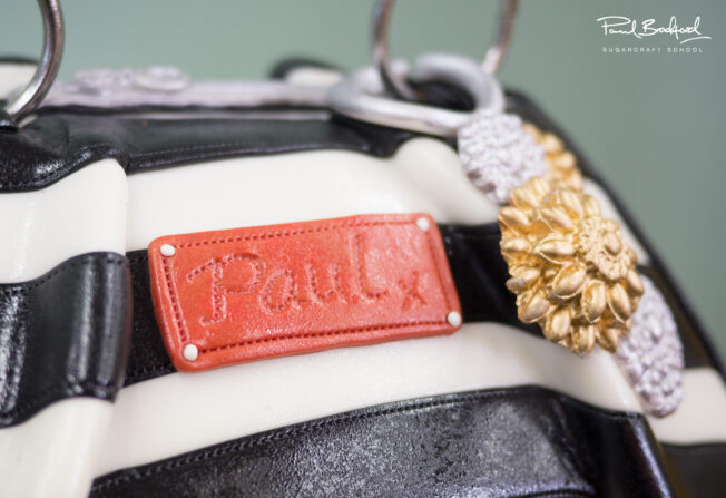 Close up of badge on handbag cake