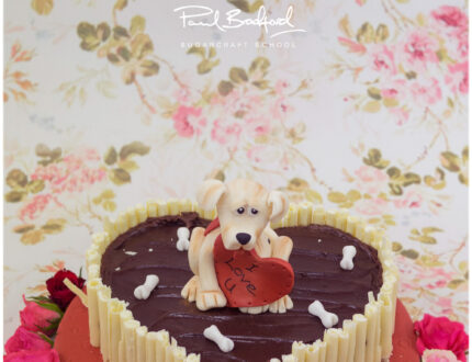 Modelled dog sat on chocolate cake