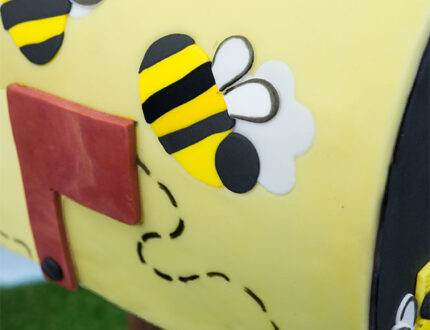 Close up of decorative bee on post box cake