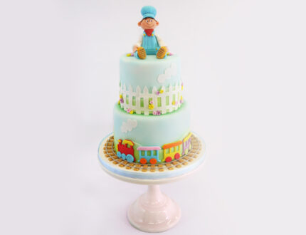 little boy model on top of two tier cake