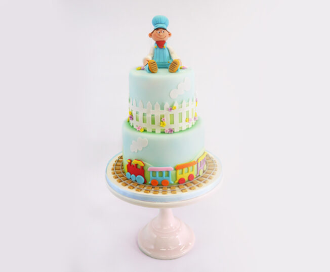 little boy model on top of two tier cake
