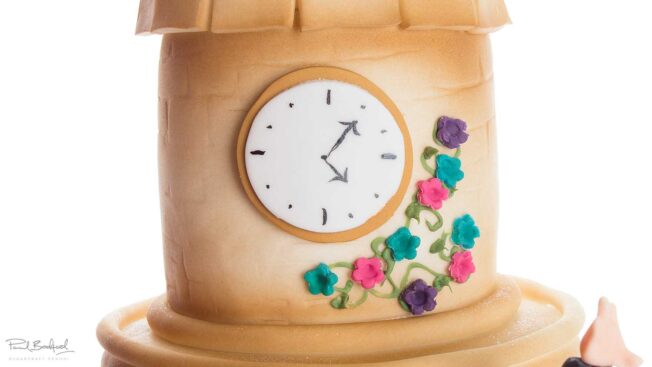 Close up of clock on bridal party cake